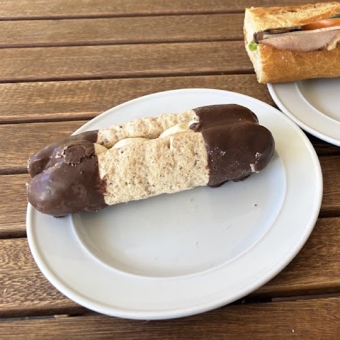A chocolate-dipped bokken poot next to a filled baguette