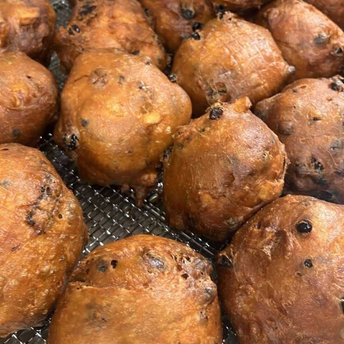 Golden oliebollen on a wire rack